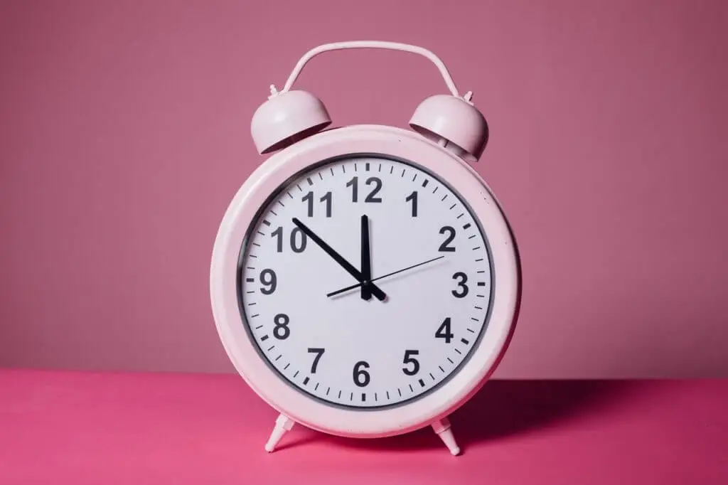 A large clock with a pink background, symbolizing time management and organization